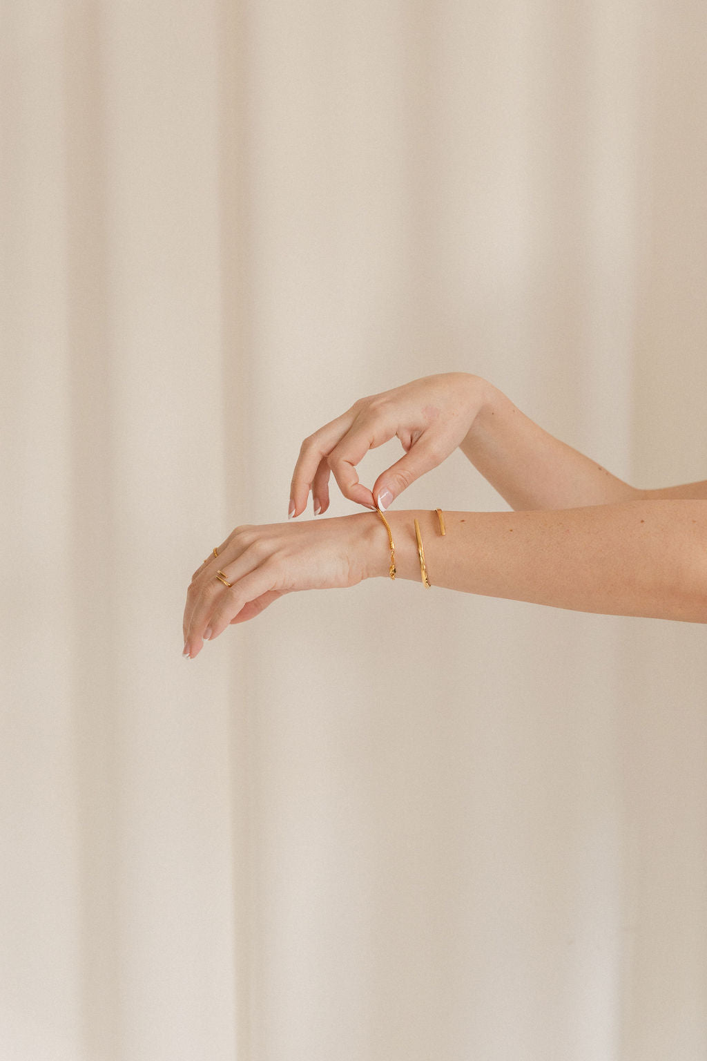 Hands showcasing gold bangles 